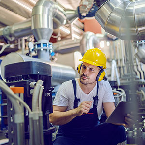 Opérateur portant un casque antibruit et intervenant dans un environnement industriel